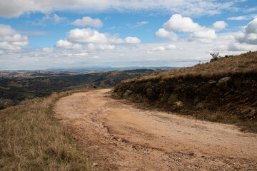 Fototapeta premium Curved Dirt Road on Hilltop Surrounded by Bleak Landscape