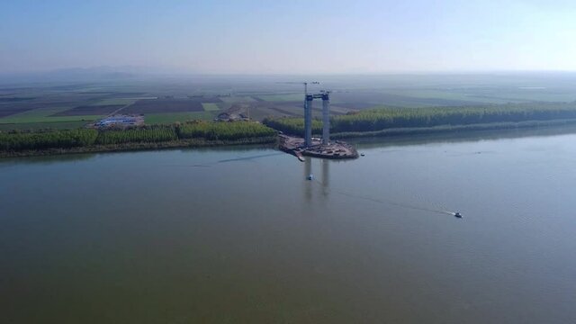 Suspended bridge under construction , over the Danube river near Galati and Braila Cities , connecting those cities with the Danube Delta natural reserve , aerial footage from the drone with the phase