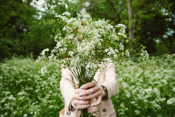 Mental Health Awareness Month, behavioral health care. Post COVID-19 pandemic mental health challenges. Red-haired young woman on green nature trees and flowers background