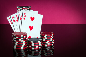 Poker cards with straight flush combination. Close-up of playing cards and chips in poker club. Free advertising space