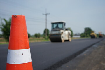 The image is blurred in the construction work. There is a red rubber cone on the front.