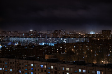 Thousands of windows of the night city in the fog