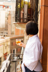 Latina woman in white shirt holding a glass of cognac, alcohol concept