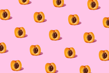 Trendy sunlight peach or apricot fruit isometric pattern on a pastel pink background. Minimal summer or healty diet concept.
