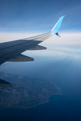 Obraz premium Commercial airplane flying over the Greek Islands of the Mediterranean sea, Looking through the plane window.