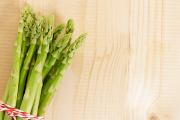 Fresh green asparagus on wooden table background.
