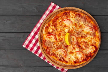 Tasty pizza on black wooden background top view