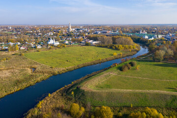 Aerial view of Suzdal town with rampart and Kamenka river on the foreground on sunny autumn day. Vladimir Oblast, Russia.. - obrazy, fototapety, plakaty