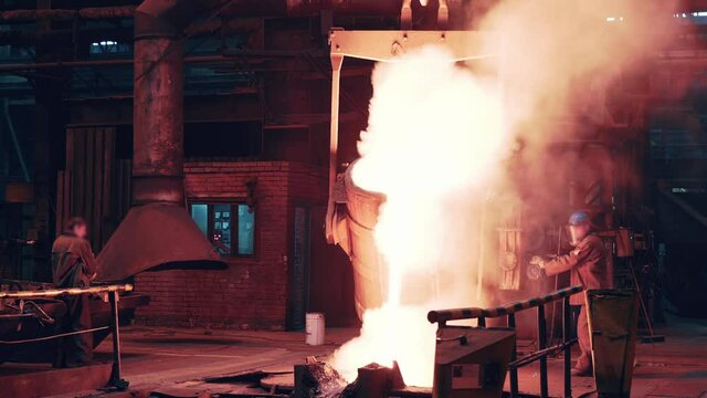 Process of molten iron pouring from blast furnace into ladle container, steel foundry factory, heavy metallurgy industry.