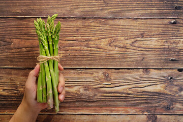 Fresh green asparagus in hand