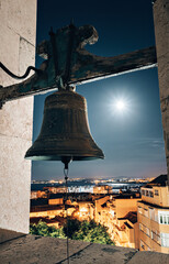 Fototapeta premium a large bell illuminated by the moon. view of the night city