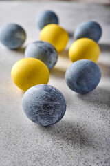 Vertical orientation homemade Easter colored yellow and grey marble eggs. Close up, selective focus