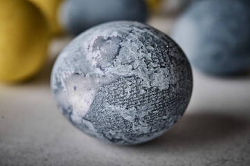 Homemade Easter colored grey marble egg. Macro, selective focus