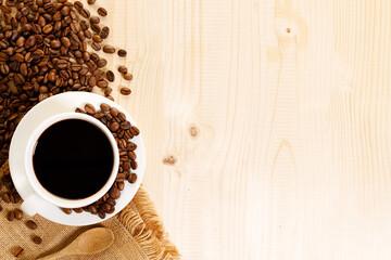 Cup of black coffee with coffee beans.