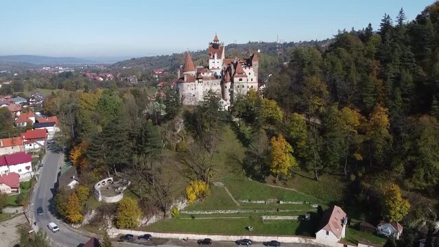 The famous medieval Bran Castle , the residence of count Dracula , situated on a hill in Bran County , Transylvania , Romania , aerial drone footage  , autumn season.