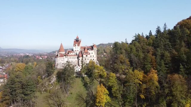 The famous medieval Bran Castle , the residence of count Dracula , situated on a hill in Bran County , Transylvania , Romania , aerial drone footage  , autumn season.