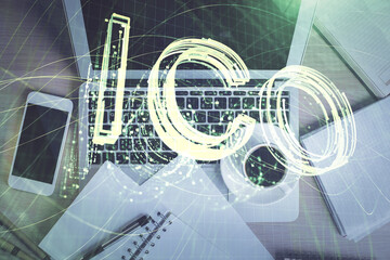 Blockchain theme hologram drawings over computer on the desktop background. Top view. Double exposure.