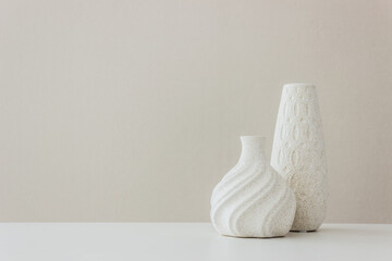 A white vase on the table - obrazy, fototapety, plakaty