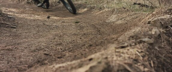 MTB bike wheel brakes on berm or turn wheel tyre soil fly close up