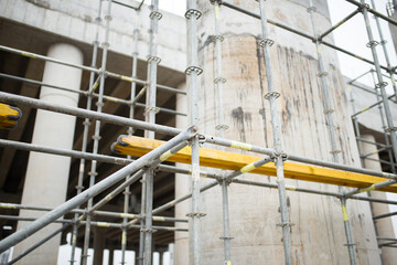 Fototapeta premium Close-up of scaffolding against the background of reinforced concrete supports of the transport bridge