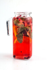 Isolated glass jug of red berry lemonade with mint and lemon