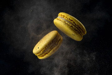 flying macaroons on a black background, freezing in motion with cocoa.