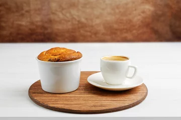 Fotobehang Homemade cinnamon bun from yeast dough in white ceramic mold and cup of coffee espresso on round wooden tray. Copyspace. © mark_ka