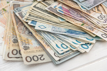 pile of us dollar and polish zloty banknotes as background