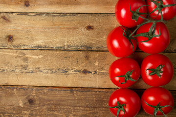 Tomatoes on a wooden background. Ripe and fresh tomatoes. Healthy vegetables. There is a place for an inscription or logo