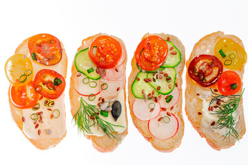 Whole grain bread or sandwiches with cheese, cucumber, radish, tomatoes, onion, dill, sunflower pumpkin seeds on white background.