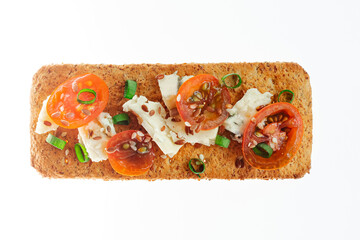 Whole grain cookies, thin crisp bread, with cheese, tomatoes, green onion and flax seeds on white background