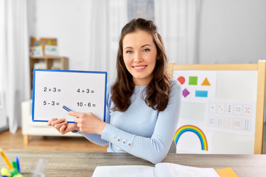 distant education, school and people concept - happy smiling female math teacher with mathematics having online class at home