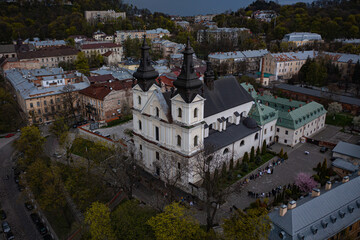 Fototapeta na wymiar Aerial view on Carmelite Church (Michael the Archangel church) in Lviv, Ukraine from drone. Consecration of Easter food, cakes, eggs