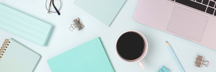 Banner with laptop and scattered office supply on a blue background. Distance education, online business, remote work concept.