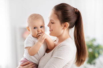 family, motherhood and people concept - happy mother with little baby daughter at home