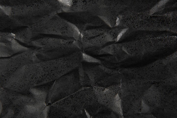 black crumpled paper texture background.