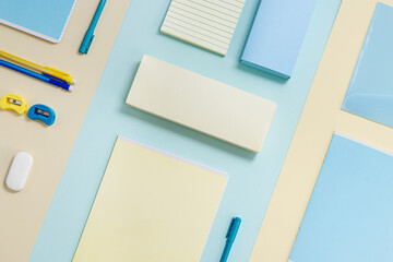 Stationary school supplies in yellow and blue tone. Office accessories on paper background.