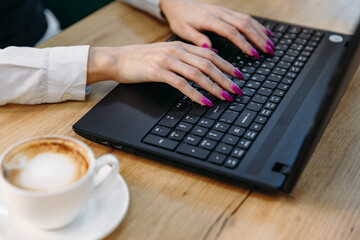 Close-up of consultant woman's hands typing on keyboard while sitting in office and working on computer.