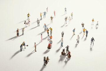 Top view of people (miniature toys) with long shadows keep distance away in public during sunrise or sunset.Social distancing during COVID-19 coronavirus outbreak spreading concept.