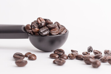 coffee beans in a spoon on white background