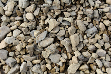 A lot of stones of different shapes, which form a solid embankment and a unique pattern.