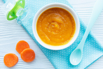 Baby carrot mashed with spoon in bowl