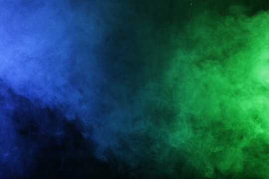 Smoke in blue green light on black background