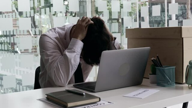 Put the work equipment in the office in a large brown box, Businessmen are keeping work documents and personal belongings due to resignation or being fired, termination of employment.