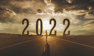 2022 behind the tree of empty asphalt road at golden sunset and beautiful blue sky. Concept for...
