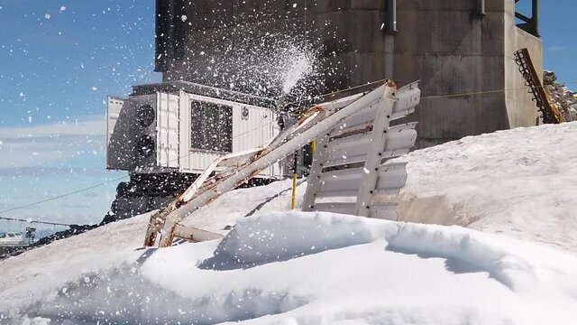 snowflakes gun maker at 3028 meters on top of Titlis mountain peak in summer. Between cantons of Obwalden and Bern in Switzerland, Europe. SLOW MOTION