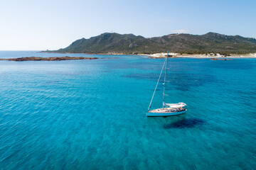 Obraz premium ITALY - Sardinia - Sailboat at anchor at the Capo Comino beach on the east coast of Sardinia