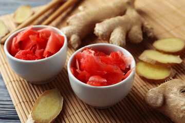 Concept of tasty eating with pickled ginger and chopsticks on wooden table