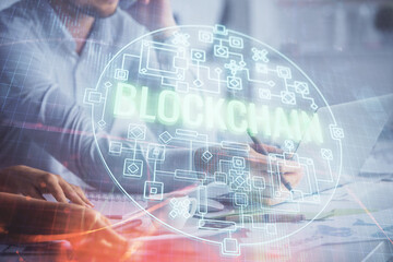 Double exposure of man and woman working together and crypto finance theme hologram. Blockchain business concept. Computer background.