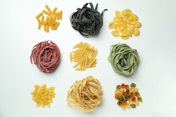 Different uncooked color pasta on white background